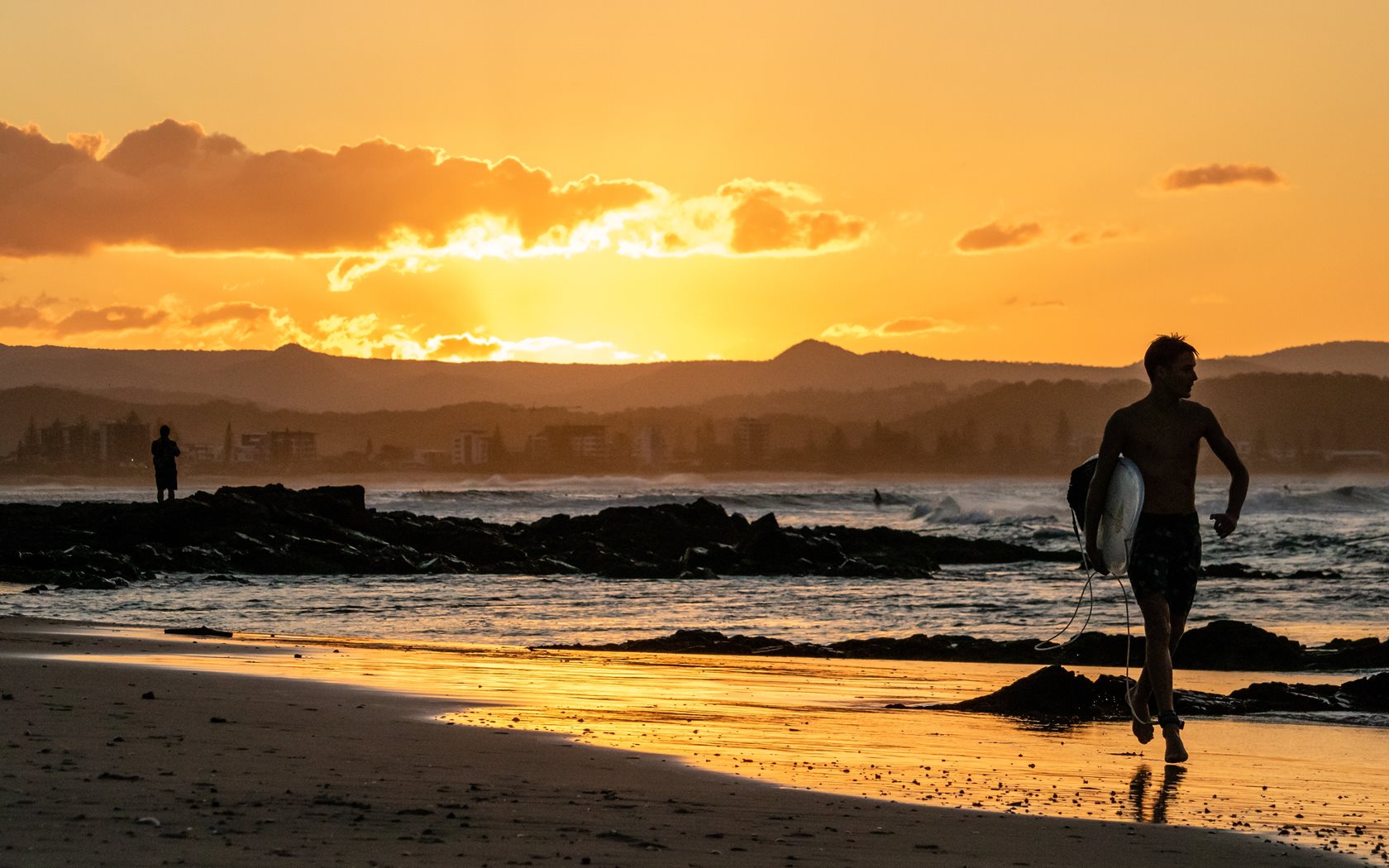 surfer-running-in-cooly-with-sunset